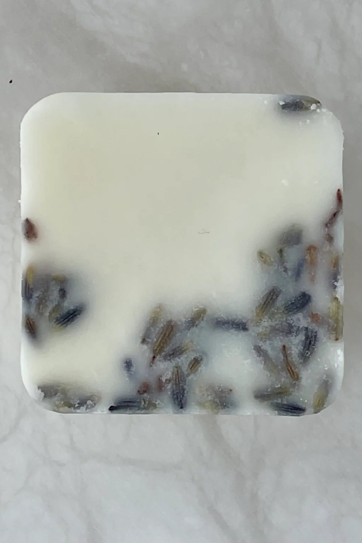  single white wax melt with pieces from the scent profile in the wax.