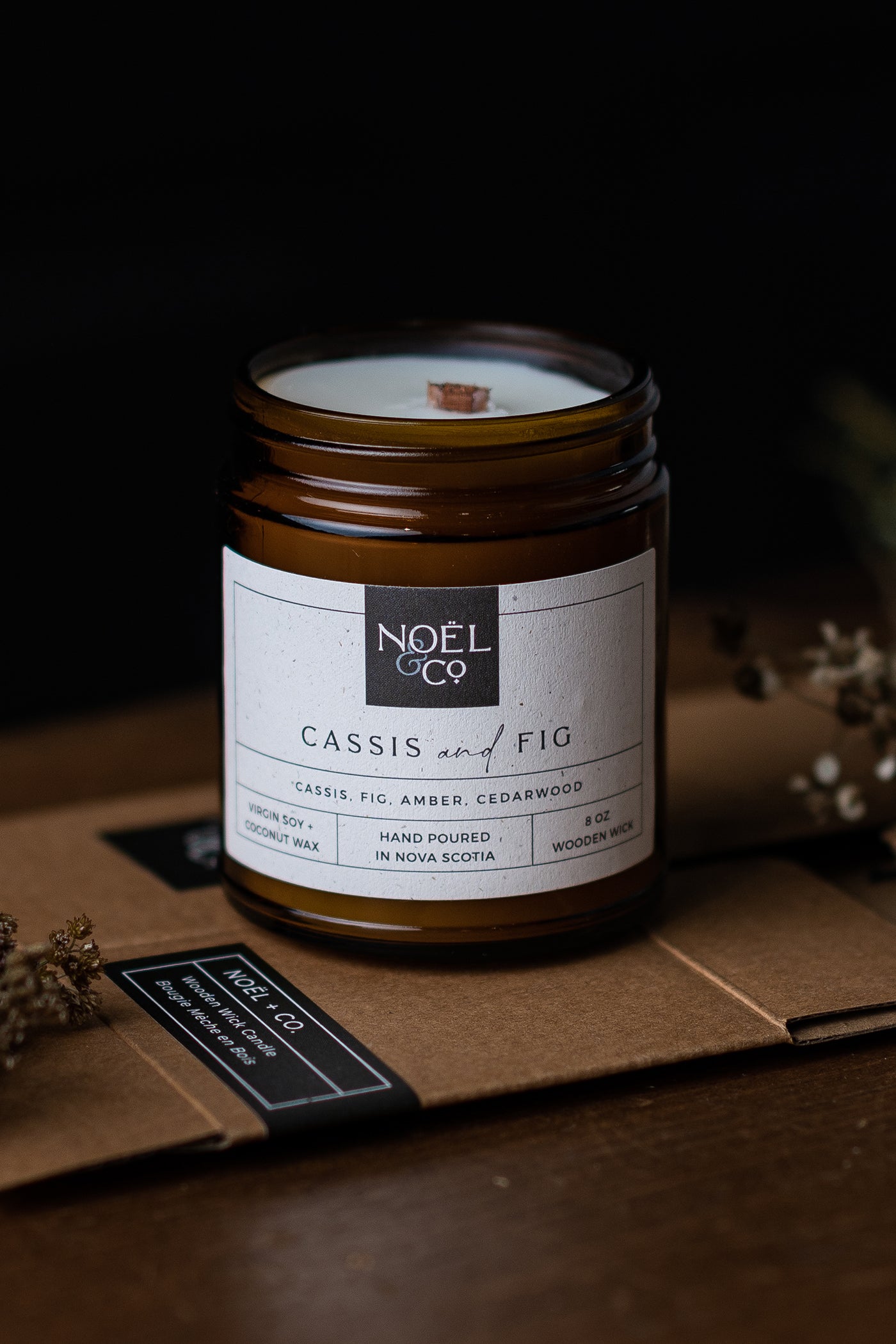 A Noel and Co Cassis and Fig candle in a amber glass jar.