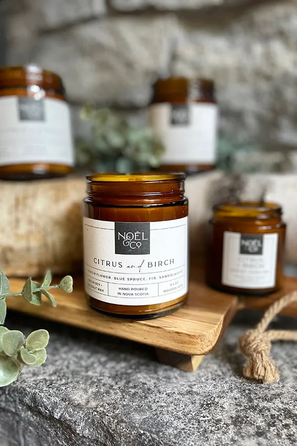 4 Noel and Co candles in amber glass jars.
