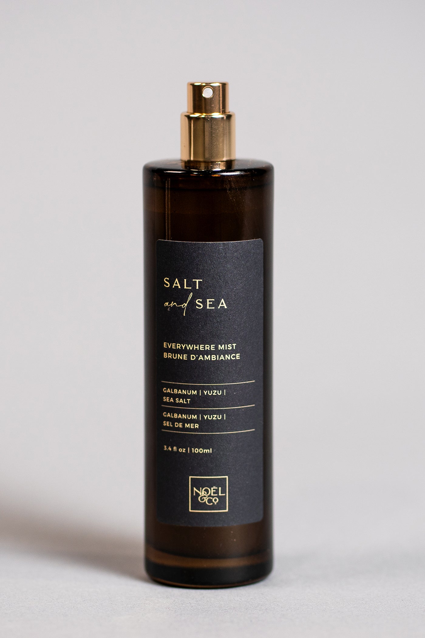 A bottle of Noel and Co 'Salt & Sea' everywhere mist spray with a black label and gold cap, displayed against a neutral background.